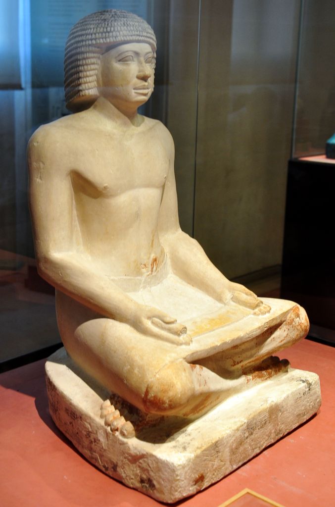 Ancient Egyptian limestone sculpture of a seated scribe at work from the Fifth Dynasty, 2494 to 2345 BC